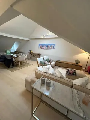 a living room with a couch and a table at Historic Charm Penthouse Leuven in Leuven