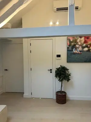 a room with two white doors and a potted plant at Historic Charm Penthouse Leuven in Leuven