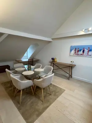 a dining room with a table and chairs and a painting at Historic Charm Penthouse Leuven in Leuven