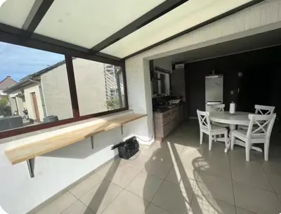 a patio with a table and chairs and a kitchen at Dar Laila in Vilvoorde