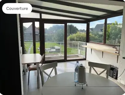 a room with a table and chairs and a window at Dar Laila in Vilvoorde