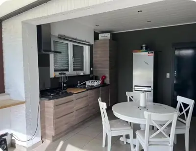 a kitchen with a white table and chairs and a refrigerator at Dar Laila in Vilvoorde