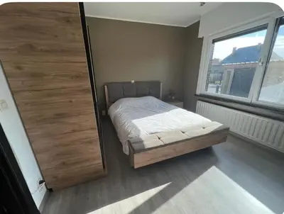 a bedroom with a bed and a large wooden door at Dar Laila in Vilvoorde