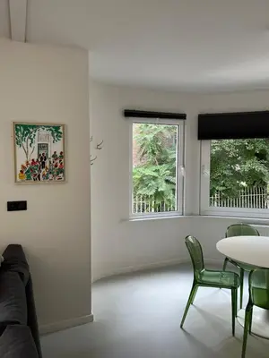 a living room with a table and chairs and a window at Knus appartement centrum Gent in Ghent
