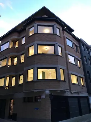 a tall building with lights in the windows at Knus appartement centrum Gent in Ghent