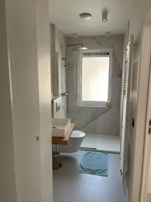 a bathroom with a sink and a toilet and a window at Knus appartement centrum Gent in Ghent