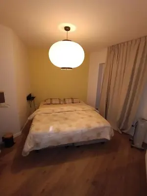 a bedroom with a large bed with a large light at Localização privilegiada in Brussels