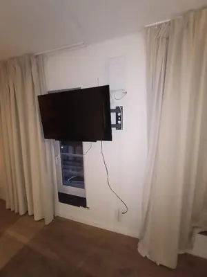 a flat screen tv hanging on a wall next to a window at Localização privilegiada in Brussels