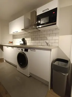 a kitchen with a washing machine and a microwave at Localização privilegiada in Brussels