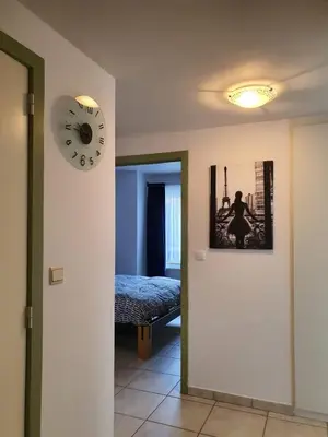 a room with a clock on the wall and a bed at Appartement 2 chambres dans le centre de Vilvoorde in Vilvoorde