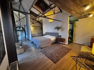 a bedroom with a white bed in a room at Stylish Loft with Industrial Charm in Kortenberg