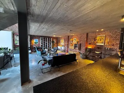 a living room with a couch and a brick wall at Stylish Loft with Industrial Charm in Kortenberg