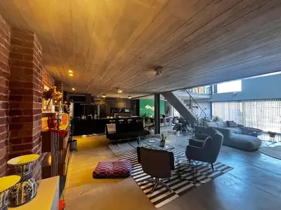 a living room with couches and chairs in a building at Stylish Loft with Industrial Charm in Kortenberg