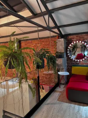 a room with a red couch and a brick wall at Stylish Loft with Industrial Charm in Kortenberg