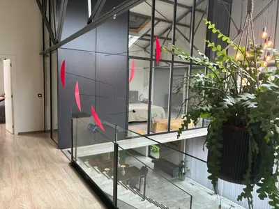 a room with a glass wall with red arrows at Stylish Loft with Industrial Charm in Kortenberg