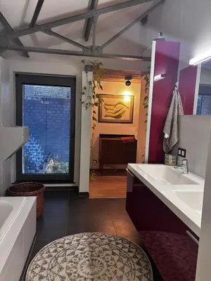 a bathroom with two sinks and a large mirror at Stylish Loft with Industrial Charm in Kortenberg