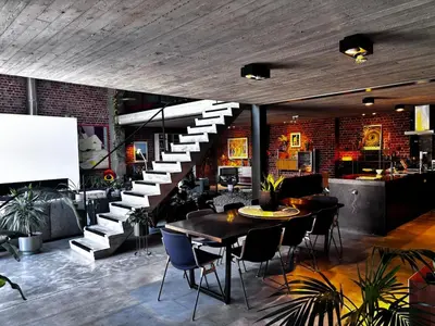 a room with a staircase and a table and chairs at Stylish Loft with Industrial Charm in Kortenberg