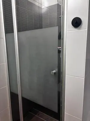 a shower with a glass door in a bathroom at Stylish Loft with Industrial Charm in Kortenberg