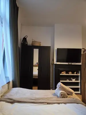 a bedroom with a bed and a flat screen tv at The Amber Lounge, 1040 Brussels in Brussels