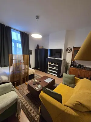 a living room with a couch and a tv at The Amber Lounge, 1040 Brussels in Brussels