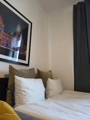a bed with white sheets and pillows in a room at The Amber Lounge, 1040 Brussels in Brussels