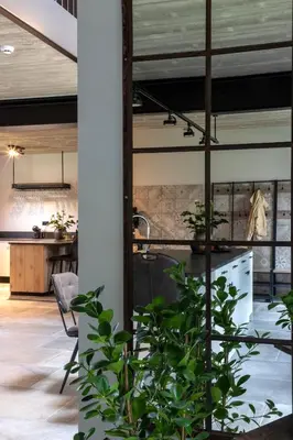a kitchen and living room with a plant at Zeer ruime groepswoning voor 24p in Turnhout