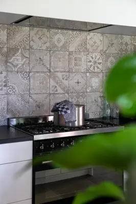 a kitchen with a stove top oven with tiles at Zeer ruime groepswoning voor 24p in Turnhout