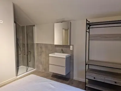 a bathroom with a bed and a sink and a shower at Zeer ruime groepswoning voor 24p in Turnhout
