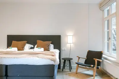 a bedroom with a large bed and a chair at Apartment near Antwerp Cathedral in Antwerp