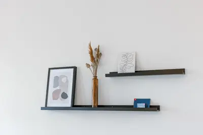 a shelf with a vase and a picture on a wall at Apartment near Antwerp Cathedral in Antwerp