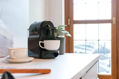 a coffee maker sitting on a counter next to a cup at Apartment near Antwerp Cathedral in Antwerp