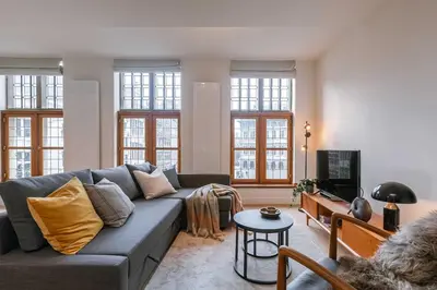 a living room with a couch and a tv at Modern Suite on Antwerp's Grand Market Square in Antwerp