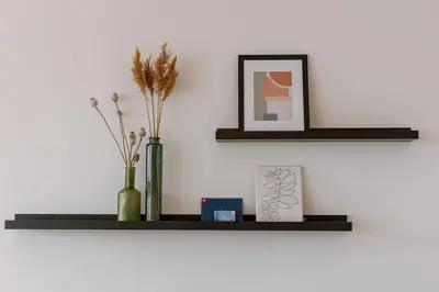 a black shelf with two vases and a picture at Modern Suite on Antwerp's Grand Market Square in Antwerp