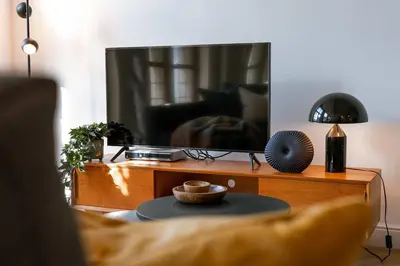 a living room with a tv and a table at Modern Suite on Antwerp's Grand Market Square in Antwerp
