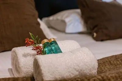two toothbrushes in a holder on a bed at Modern Suite on Antwerp's Grand Market Square in Antwerp