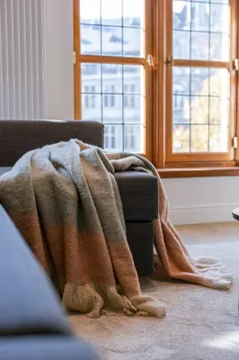 a blanket on a couch in a room with a window at Modern Suite on Antwerp's Grand Market Square in Antwerp