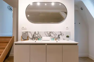 a bathroom with a sink and a mirror at Modern Suite on Antwerp's Grand Market Square in Antwerp
