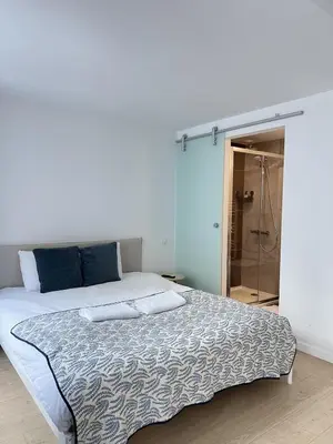 a bedroom with a large bed and a shower at Modern & Elegant Apartment near Montgomery in Brussels