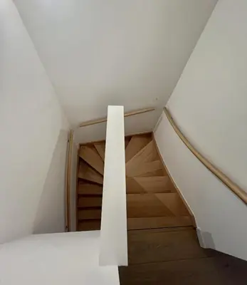a staircase in a house with white walls and wooden stairs at Modern & Elegant Apartment near Montgomery in Brussels