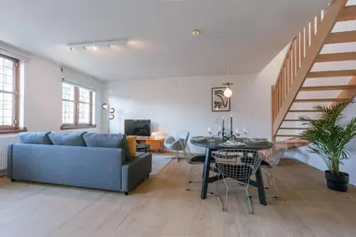 a living room with a couch and a table at Bright Duplex near Antwerp Cathedral in Antwerp
