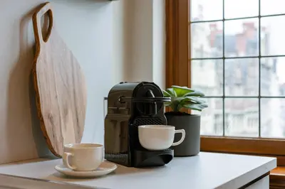a coffee maker and two cups on a counter at Bright Duplex near Antwerp Cathedral in Antwerp