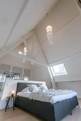 a bedroom with a large bed in a attic at Bright Duplex near Antwerp Cathedral in Antwerp
