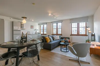 a living room with a couch and a table at Bright Duplex near Antwerp Cathedral in Antwerp