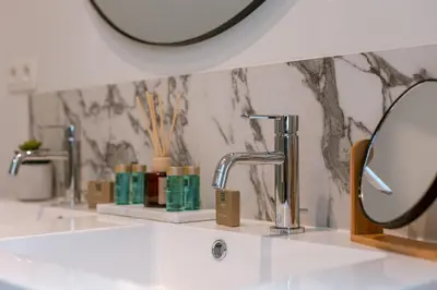 a bathroom with a white sink and a mirror at Bright Duplex near Antwerp Cathedral in Antwerp
