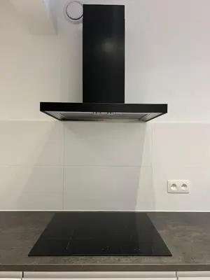 a kitchen with a black shelf on a white wall at Chic & Bright near Montgomery in Brussels