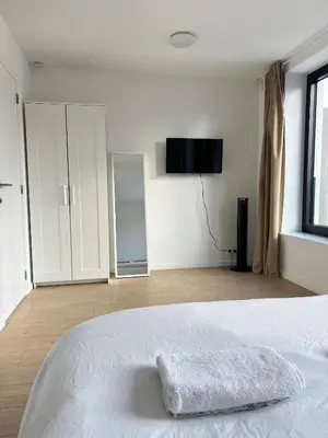 a white bedroom with a bed with a towel on it at Chic & Bright near Montgomery in Brussels