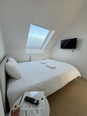 a bedroom with a bed with a window and a table at Chic & Bright near Montgomery in Brussels