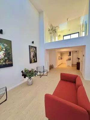 a living room with a red couch and a staircase at Chic & Bright near Montgomery in Brussels