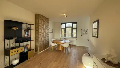 a living room with a table and a dining room at Chez Pomme in Brussels