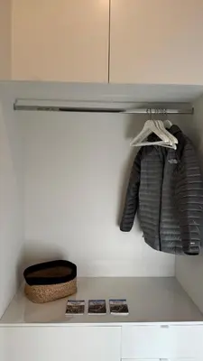 a shelf in a closet with some clothes and a basket at Chez Pomme in Brussels